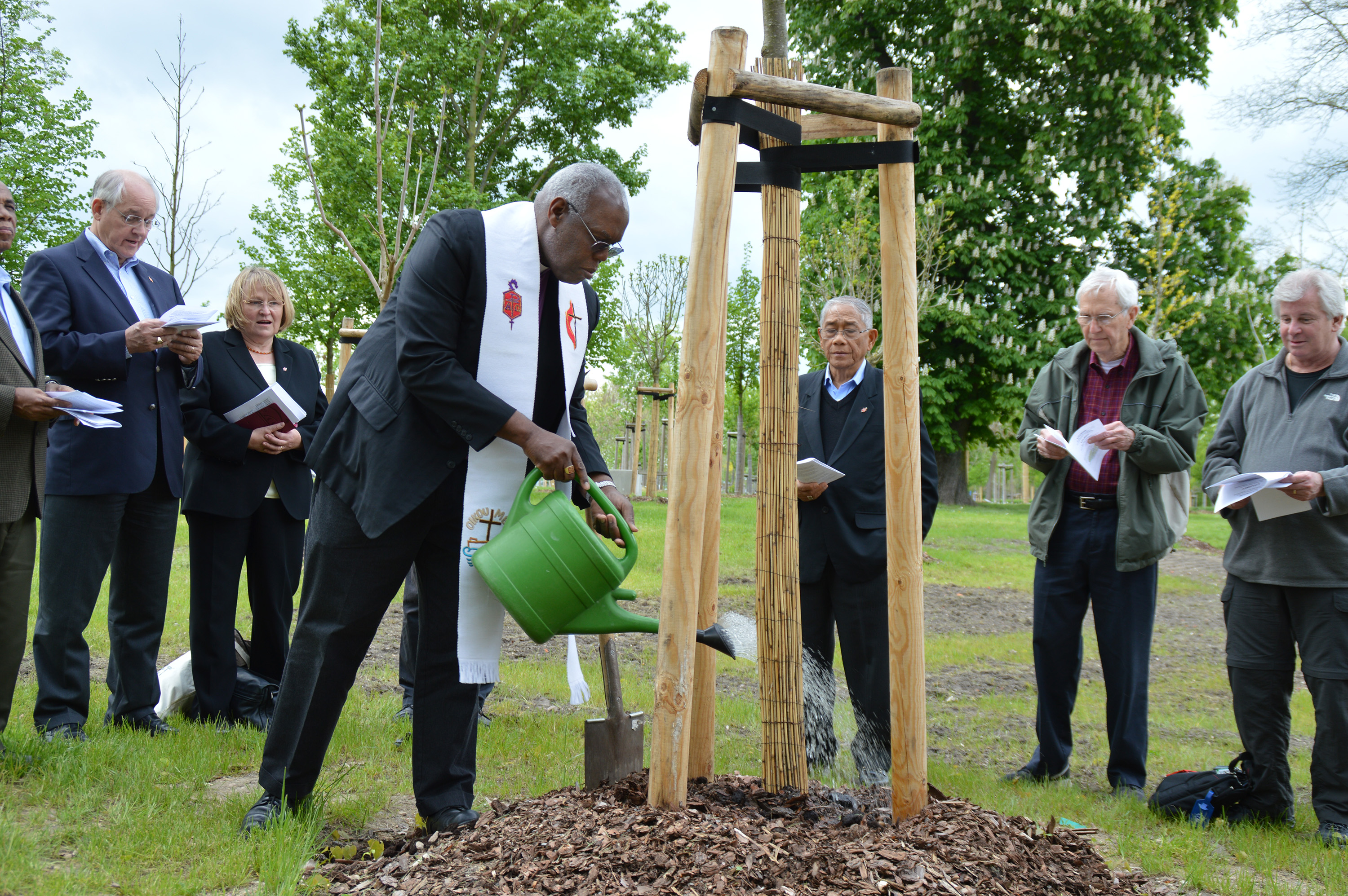 Bishops, waters a newly planted tree in the Luther Garden in Wittenberg, Germany, in preparation for the 500th anniversary of the Protestant Reformation in October 2017. The Lutheran World Federation invited churches around the globe to plant a tree in the garden and another in their area in advance of the event. File photo by Klaus Ulrich Ruof.