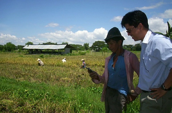 kiwanja-ken-banks-philippines-rural-1 Two men in a rural area of the Philippines check a mobile phone. Photo by Ken Banks, kiwanja.net.