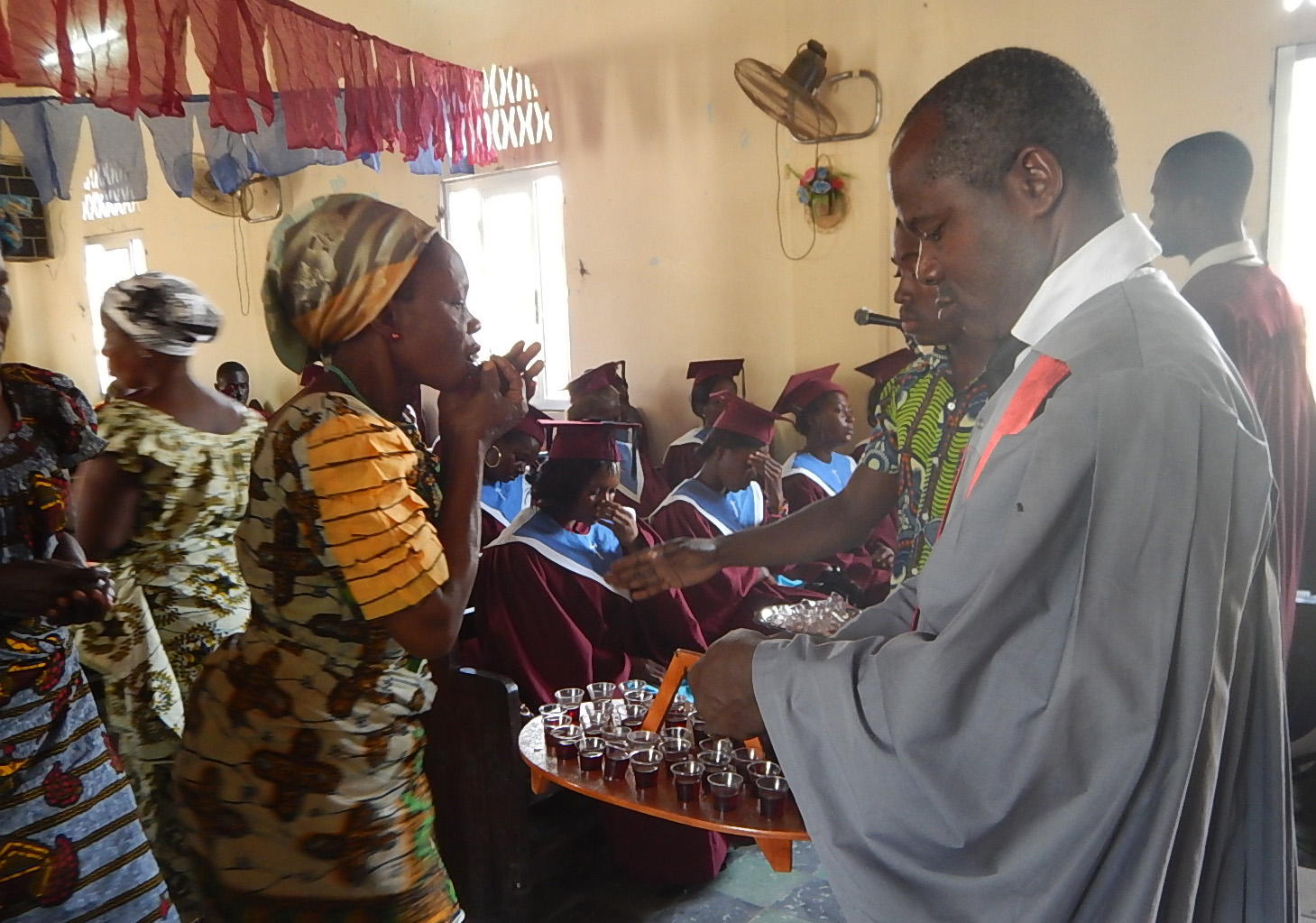 Lay pastor Raphaël Aboua (right) helps serve Holy Communion at Ebenezer Beago United Methodist Church in Abidjan, Côte d'Ivoire. Photo by Isaac Broune, UMNS.