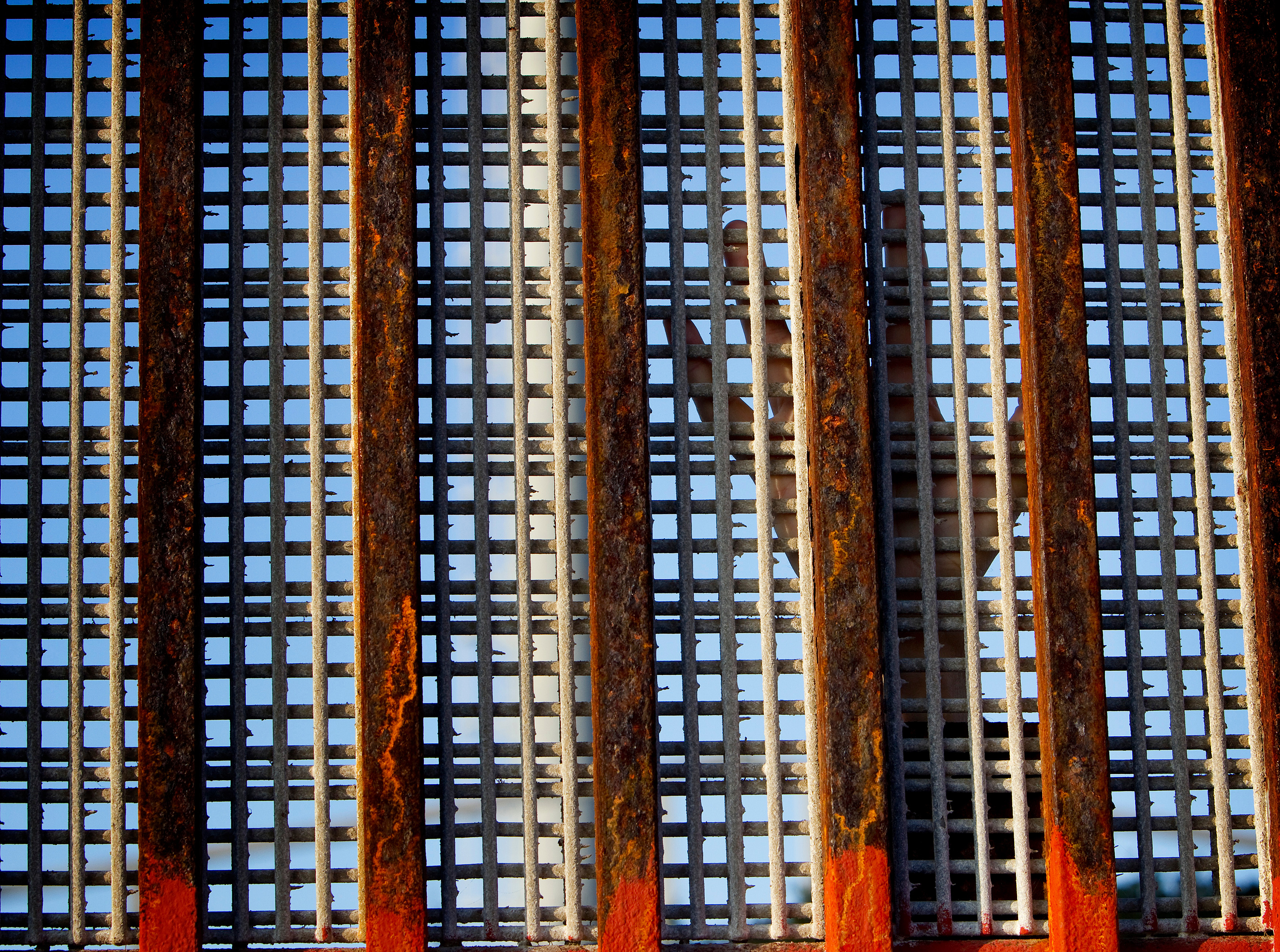 A person standing in the United States reaches their hand toward Mexico along the border fence at El Faro Park in Tijuana, Mexico, in 2012. United Methodists are joining opposition to a new "zero tolerance" policy that is separating immigrant families. File photo by Mike DuBose, UMNS.