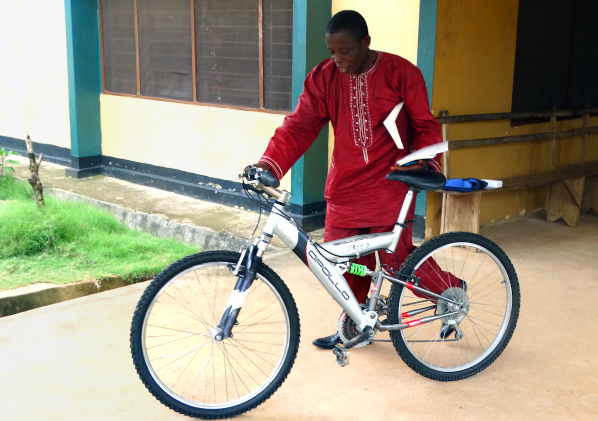 The Rev. Canon James George of the Anglican Church walks away with a new bicycle, a gift to his church after a three-day Bikes and Bibles training session in Bo, Sierra Leone. The program aims to support clergy engaged in rural evangelism by providing them with bicycles, motorcycles and Bibles to work in areas that are difficult to reach. Photo by Phileas Jusu, UMNS.