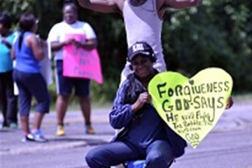 A demonstrator in Ferguson, Missouri holds a poster about forgiveness after the shooting of Michael Brown led to days of racial unrest in 2014. Image by Loavesofbread, shared via Wikimedia Commons.