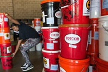 Edna Rajan stacks flood buckets from the United Methodist Committee on Relief at a warehouse in Lafayette, Louisiana in 2016.