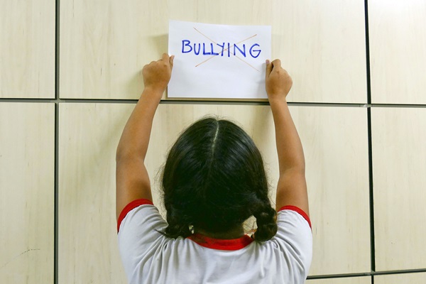 Child holds anti-bullying sign. Photo illustration courtesy of Wikimedia Commons/Senado.