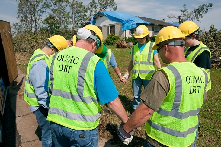 Volunteers from Ozark (Mo.) United Methodist Church's disaster response team pray before beginning to clear storm damage in Joplin, Mo. File photo by Mike DuBose, United Methodist Communications. Volunteers from Ozark (Mo.) United Methodist Church's disaster response team pray before beginning to clear storm damage in Joplin, Mo. File photo by Mike DuBose, United Methodist Communications.