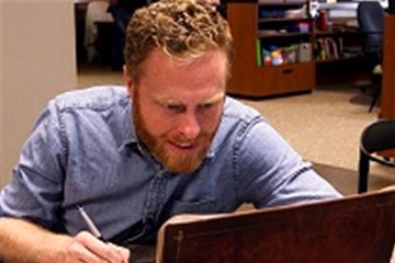 Cartoonist and pastor The Rev. Charlie Baber demonstrates how he draws his Wesley Bros comic strip. Video image courtesy of United Methodist Communications.