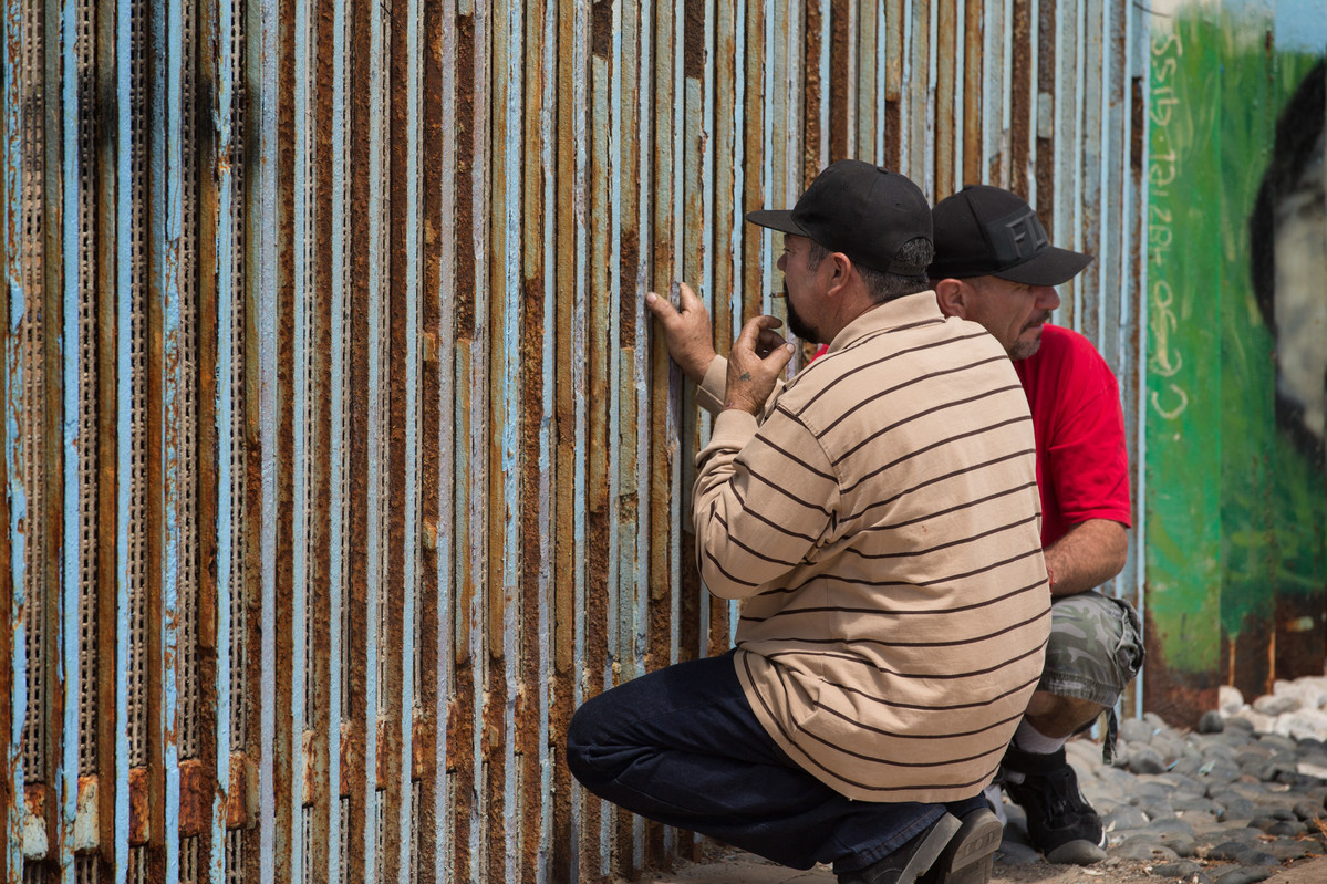 Family members visit through the border fence that separates Mexico from the U.S. at El Faro Park in Tijuana, Mexico.
