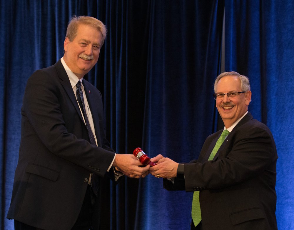 Incoming Council of Bishops president Bishop Ken Carter receives the gavel from Bishop Bruce Ough. Photo courtesy of the Council of Bishops.