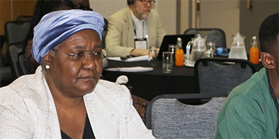 Bishop Joaquina F. Nhanala of Mozambique and agricultural missionary Innocent Afful listen to The United Methodist Church’s plans for existing land in Africa during an agricultural summit held Jan. 13-16 in Johannesburg.