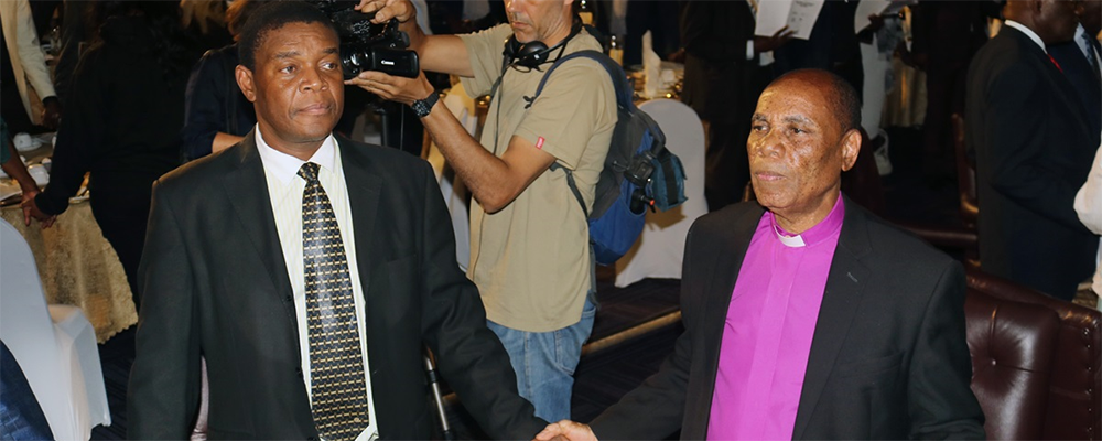 Zimbabwe Area Bishop Eben K. Nhiwatiwa, episcopal leader for the Zimbabwe East and Zimbabwe West conferences, joins hands with other Christians and political leaders at a national prayer breakfast and dialogue Feb. 7 in Harare, Zimbabwe.