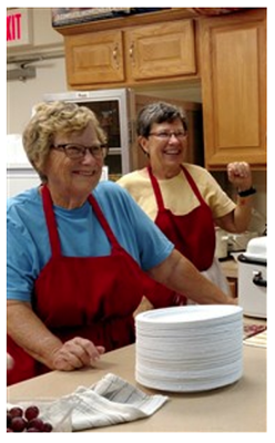 Biscuits, pancakes, or both? Louise Foster and Diane Powell greet guests at the counter during Monday Meals.