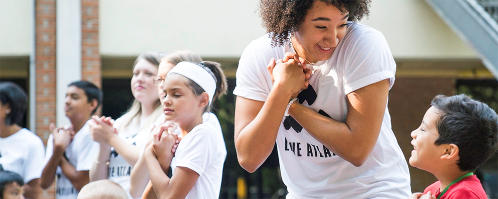 Volunteer from the Corner's Academy interact with one of the young participants.