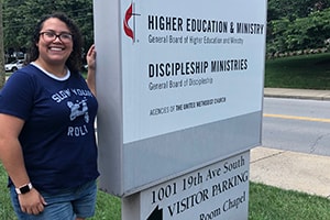 Brittani Fletcher stands next to the General Board of Higher Education and Ministry Agency’s sign in Nashville, TN. 