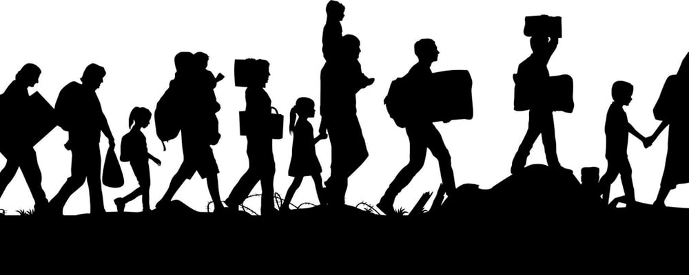 Silhouette of imigrants walking to freedom. Stock photo.
