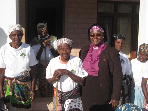 United Methodist Bishop Joaquina Nhanala (center) celebrates the completion of three permanent shelters with widows at the Hanhane Shelter. Photo by Naftal Massela.