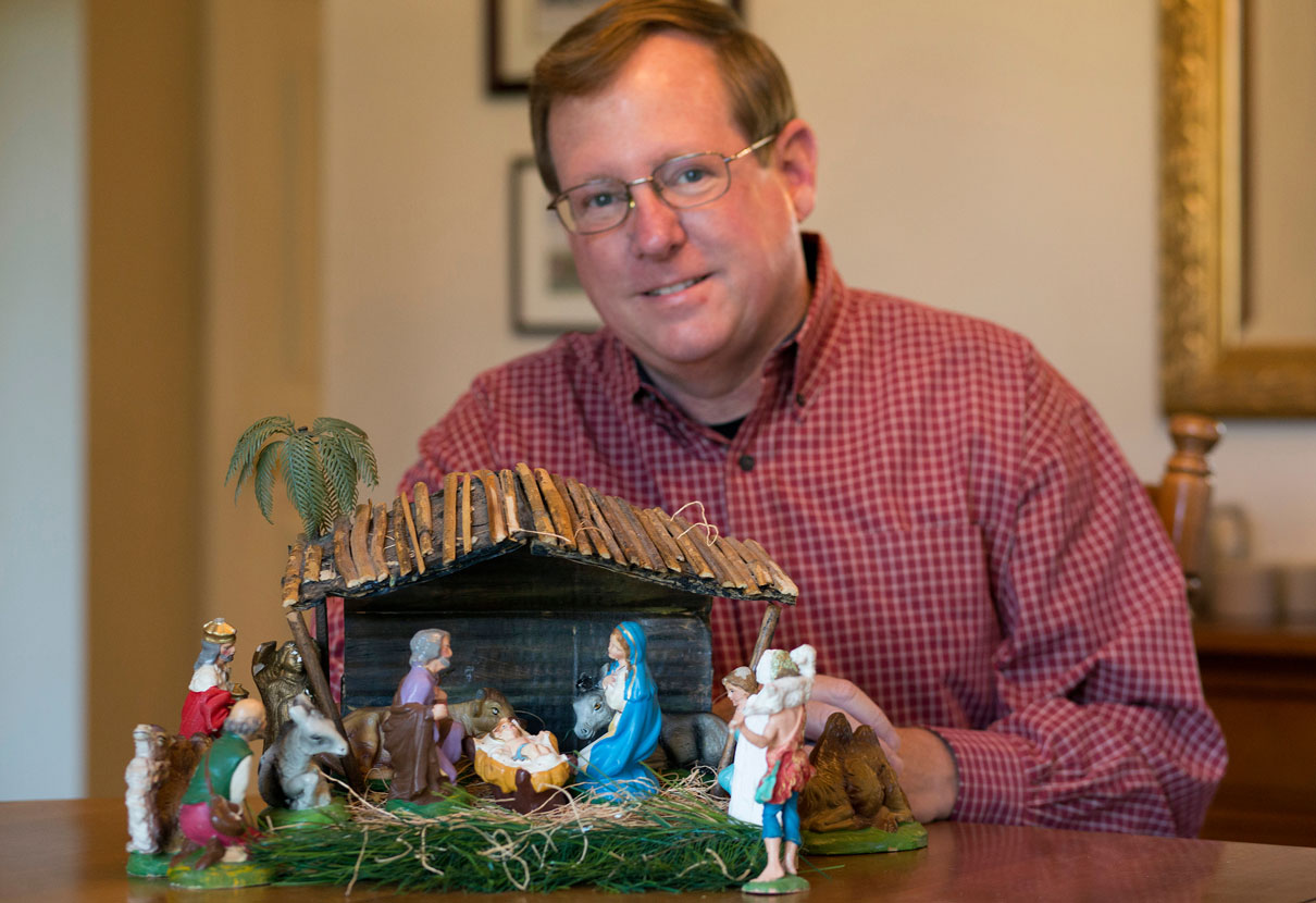 Gilbert Lovell of Franklin, Tenn., poses with a Nativity set made by his mother. Photo by Mike DuBose, United Methodist Communications.