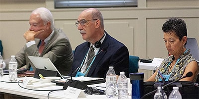 Members of the United Methodist Commission on General Conference listen during a presentation at their meeting in Lexington, Ky. From left are: Bishop Thomas J. Bickerton, the Rev. Gary George and Kim Simpson. Bickerton is the Council of Bishops representative on the commission, George is secretary and Simpson is chair. Photo by Heather Hahn, UM News.
