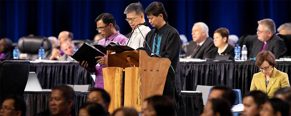 Bishops Rodolfo Alfonso “Rudy” Juan (left), Ciriaco Q. Francisco (center) and Pedro M. Torio Jr. lead a prayer for the Philippines and Southeast Asia during the 2019 United Methodist General Conference in St. Louis in February. The Philippines Central Conference College of Bishops, meeting in Manila, signed a resolution opposing dissolution of The United Methodist Church. File photo by Kathleen Barry, UM News.