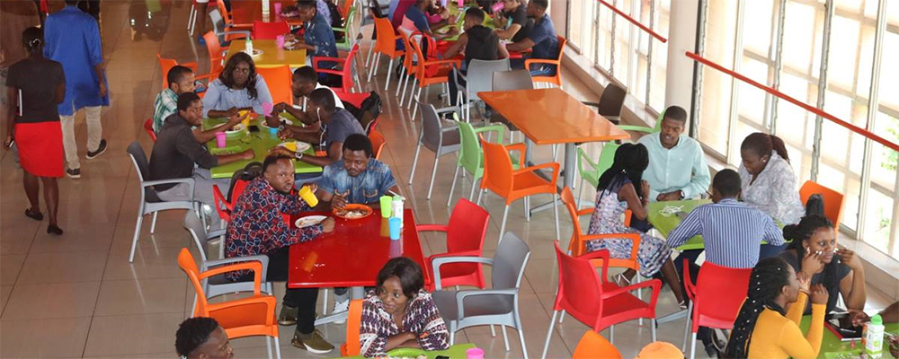 Students eat in the cafeteria at Africa University, which serves about 1,200 people during lunch and dinner. To manage during tough economic times, the food services department has been stocking up on food and managing portions. Photo by Eveline Chikwanah, UM News.