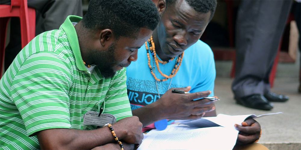 Eric Nyenow (left) and Emmanuel Gbuie, residents of the United Methodist New Life Recovery Center, review their notes during an addiction and substance abuse seminar in Monrovia, Liberia. The United Methodist Church in Liberia hosted the seminar to help local churches expand and strengthen their recovery ministries. 