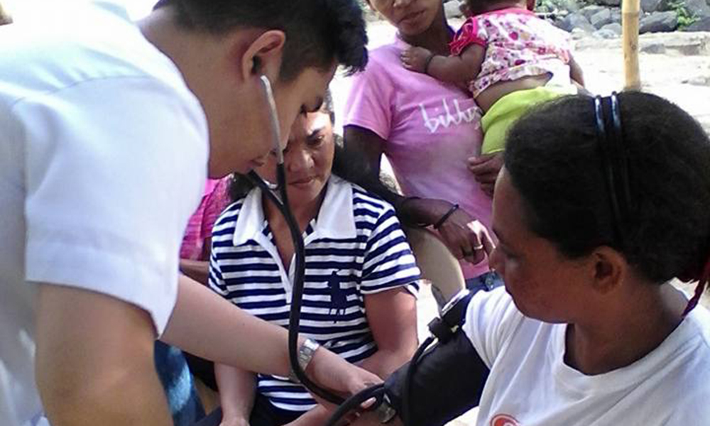 Dr. Karl Wesley E. Dillozon checks the blood pressure of a patient.