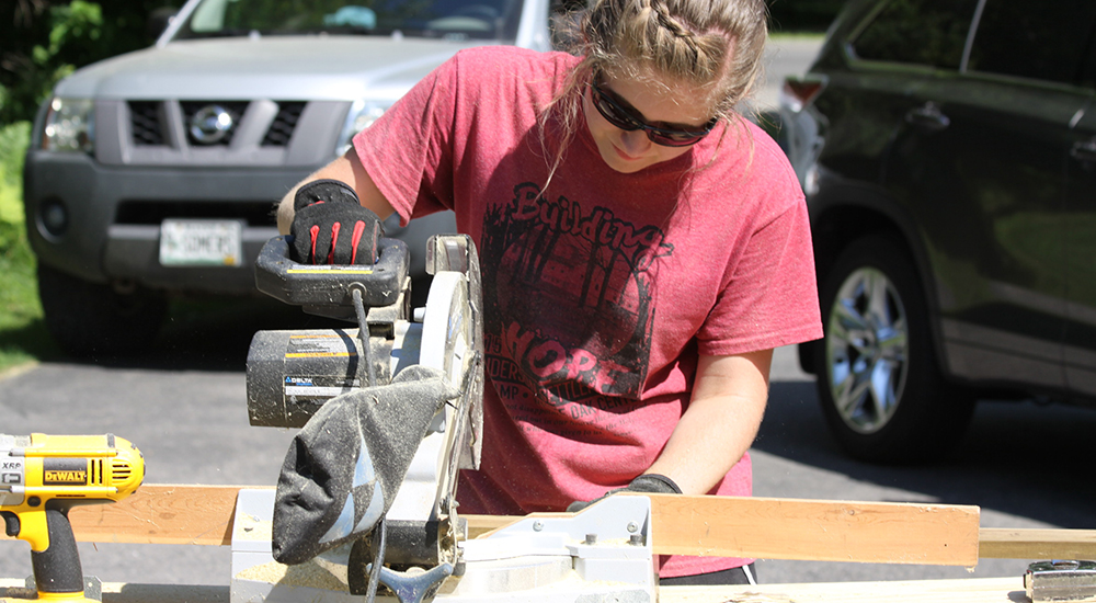 Joslyn Juhl works with table saw at community project.