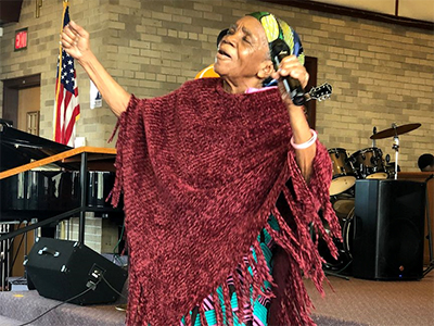 A woman offers a heart-felt prayer during worship at Restoration Community Church, an African congregation hosted by Wesley Park UMC in Wyoming, MI. ~ photo courtesy Dean Prentiss
