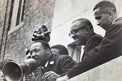 The Rev. Gilbert H. Caldwell (right) stands with the Revs. Martin Luther King Jr. (left) and Virgil Wood on the roof of a Boston public school in 1965. Photo courtesy of the Rev. Gilbert H. Caldwell.