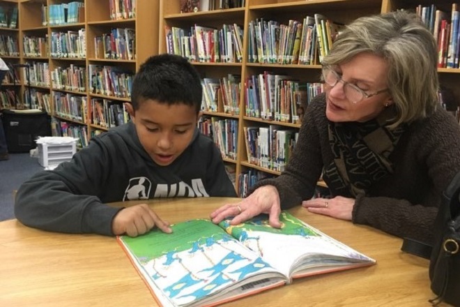 Le mentor Susan Idleman (à droite), du ministère de mentorat Kids Hope de la First United Methodist Church de Fort Worth, lit avec Johan (à gauche), un élève de quatrième. Les deux se rencontrent chaque semaine à l’école de Johan. Photo gracieuseté de Gay Ingram.