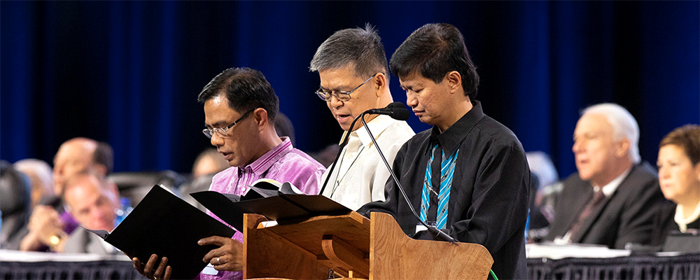 Filipino Bishops Rodolfo A. Juan, Ciriaco Q. Francisco and Pedro M. Torio Jr. lead prayer during the 2019 Special Session of the United Methodist General Conference in St. Louis on Feb. 23. The Philippines Central Conference’s coordinating council voted to extend the episcopal leadership of the three bishops through the end of 2021. File photo by Kathleen Barry, UM News. 