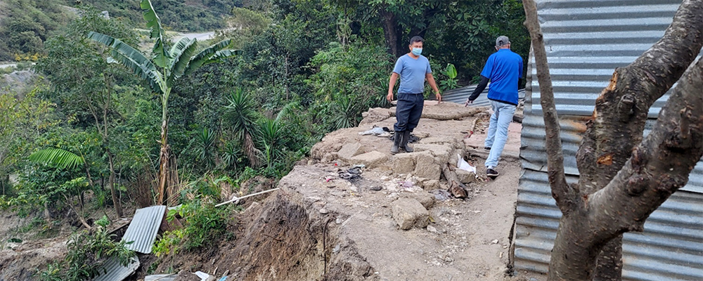 Maximo (left) inspects what is left of his house on a hillside in Cunen, Guatemala. A landslide caused by Hurricane Iota in November left little behind, but his family got out safely. PHOTO: COURTESY IENMPG