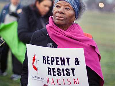 A woman holds a sign during an April 4, 2018, peace and unity rally. The rally followed the United Methodist Commission on Religion and Race’s participation in the United to End Racism Prayer Walk in Washington. File photo courtesy of the Commission on Religion and Race.