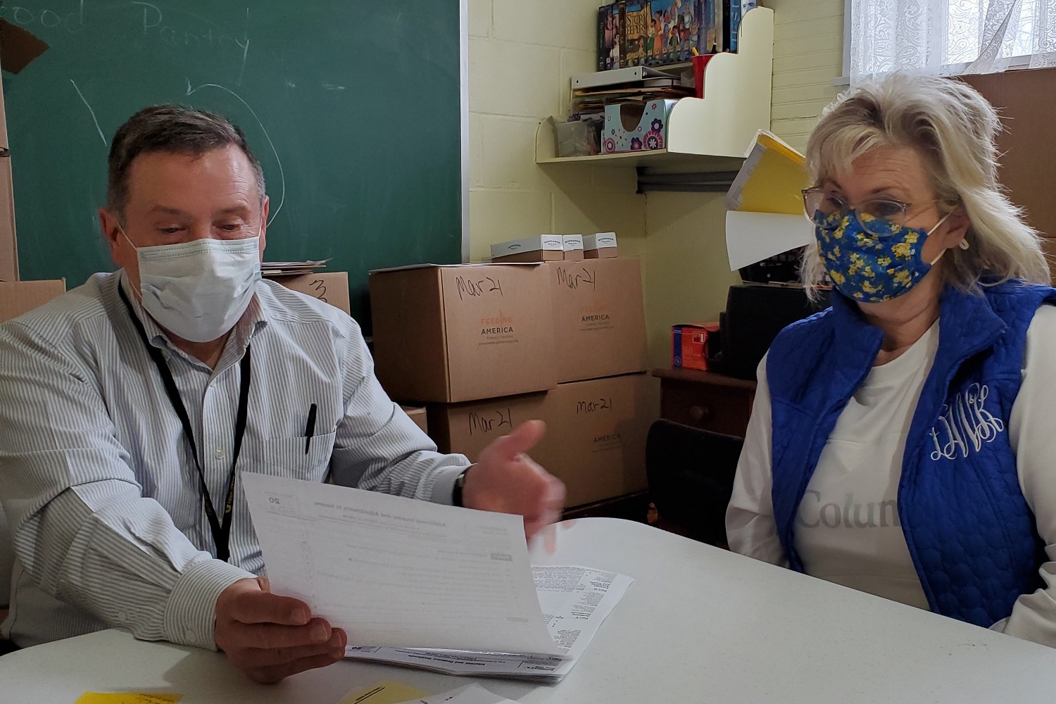 Dan Molnar (left) of Muldraugh United Methodist Church assists a client with tax return preparation through the Internal Revenue Service's VITA program. Photo by Melissa Molnar.