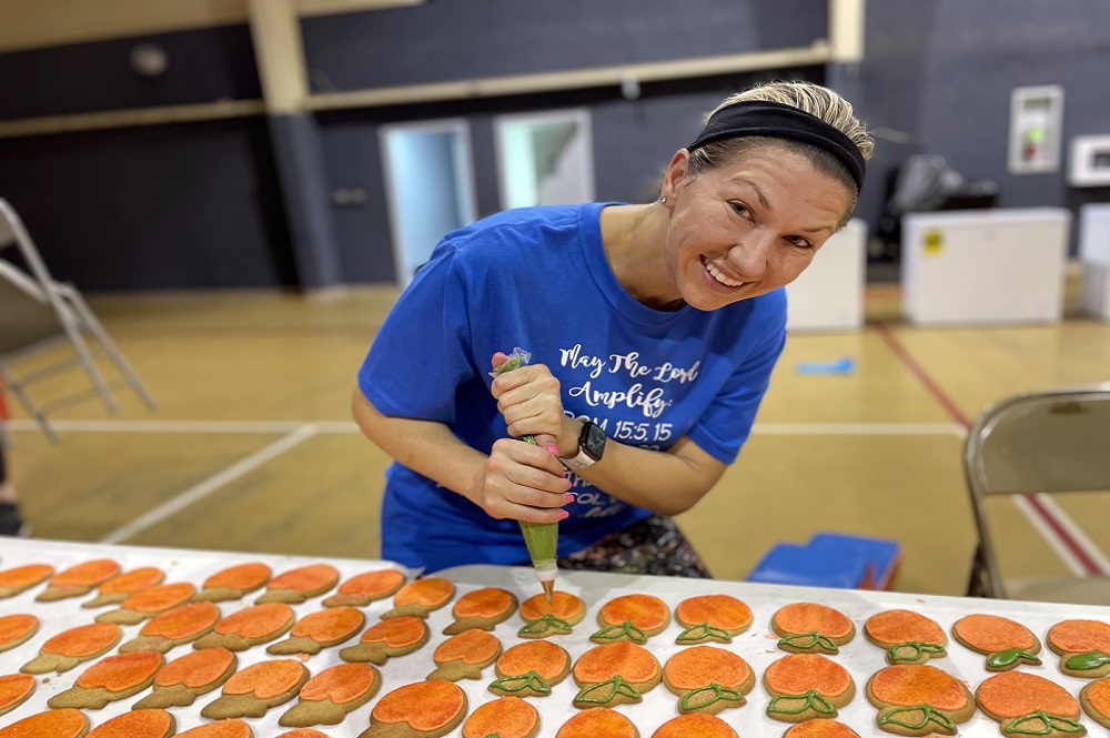 Meg Carter at Calvary United Methodist Church decorates peach cookies being sold to pay for a new church air conditioner. Photo courtesy of Calvary United Methodist Church.