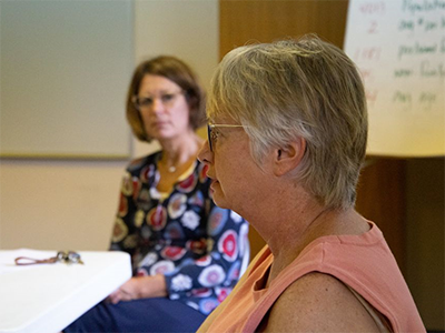 Nancy Money (left) listens to the Rev. Lisa Kelley, pastor of Sanford United Methodist Church. The village was hard hit when the dams on the Tittabawassee River burst on May 19, 2020. ~ mic photo/Mark Doyal