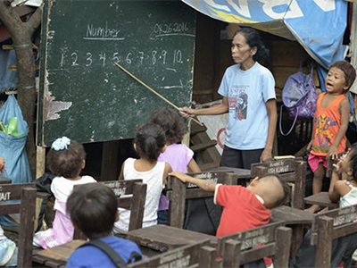 Indigenous children displaced by paramilitary violence attend school in a makeshift classroom in a church compound in Davao in 2016, on the southern Philippine island of Mindanao. Hundreds of Indigenous were living in the church center, afraid to return home. Photo © Paul Jeffrey, Life on Earth Pictures