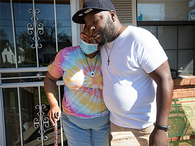 "Meals on Wheels driver Roy Reed hugs Frances Hereford after bringing lunch prepared by staff and volunteers at Bethlehem Centers. Photo by Mike DuBose, UM News.