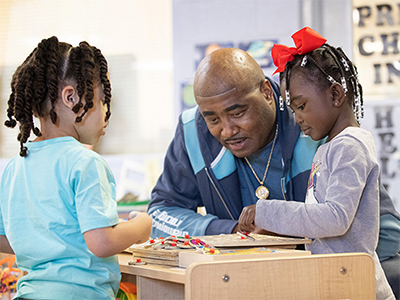 Steve Fleming visits with daycare students Malakhai (left) and Melody at Bethlehem Centers of Nashville (Tenn.) Fleming is the center’s chief executive officer. Photo by Mike DuBose, UM News.