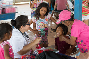 Estefania Regina de Oliviera Vieira visits with a young patient during a free medical clinic offered by volunteers from the Methodist Church in Brazil and the Florida Conference of The United Methodist Church in Murutinga, Brazil. 2018 photo by Mike DuBose, UM News. 