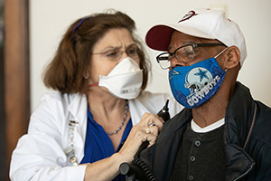 Dr. Janet Purkey prepares to examine Louis Peake’s ears during the weekly free medical clinic at Magnolia Avenue United Methodist Church in Knoxville, Tenn. Purkey is cofounder of the clinic and a professor at the University of Tennessee, Knoxville. Photo by Mike DuBose, UM News. 