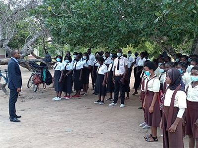 The Rev. Belmiro Jotamo speaks to students before classes begin at Bispo Henderson Secondary School in Muxungue (Sofala), Mozambique, in March. A pastor and a teacher, Jotamo has served as principal of the secondary school since graduating from Africa University in 2019. Photo by Abilio Salvador Huo