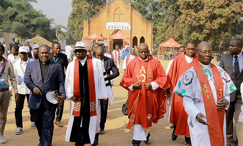United Methodist Bishop Gabriel Yemba Unda (right) leads the procession to the 100th anniversary celebration for Methodism in Congo. The celebration was held in Tunda, site of a former Methodist mission station and hospital. Photo by Philippe Kituka Lolonga, UM News.