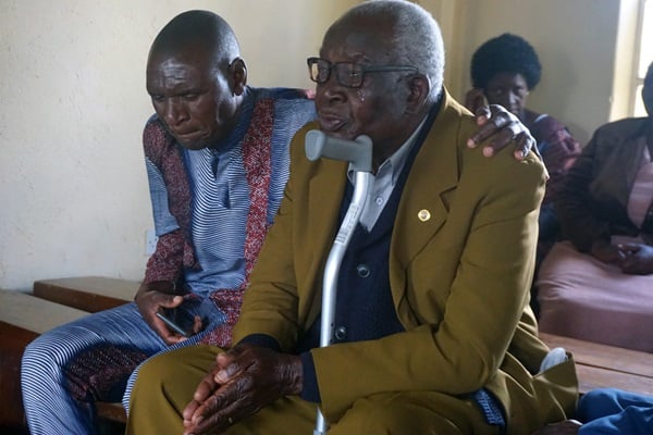Toendepi Samson Marikasi sobs with grief over the loss of his wife, Alice Marikasi, 87, and her sister, Ellah Muti, 90, during a special memorial service at St. James Hwedza United Methodist Church in Zimbabwe. Pastor Daniel Luckson consoles him. United Methodist churches in Zimbabwe held services where people who lost loved ones during COVID-19 could gather to console one another and celebrate life — things they were unable to do during pandemic restrictions. Photo by Kudzai Chingwe, UM News.