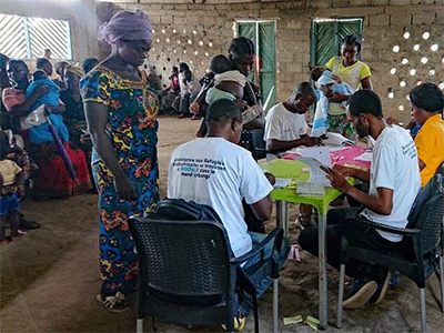 Coordinators of the United Methodist Committee on Relief’s disaster management office in eastern Congo help distribute money to displaced people from the Central African Republic living in a refugee camp in Limasa, Congo. The relief agency provided $50,000 to assist families with food. Photo courtesy of the United Methodist Committee on Relief.