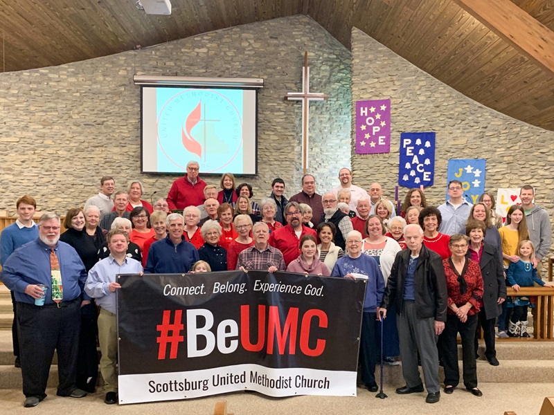 Members of Scottsburg United Methodist Church, Scottsburg Indiana pose in front of their #BeUMC sign.