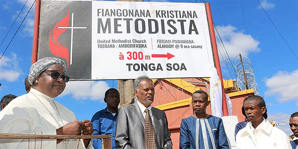 Bishop Joaquina Filipe Nhanala (left) stands next to Ratovohery Jean Aime (holding Bible) during the installation of directional signage for Ambodifasika United Methodist Church in Madagascar. The sign, donated by United Methodist Communications, was inaugurated during the bishop’s trip in February. Photo by Alvin Makunike, UM News.