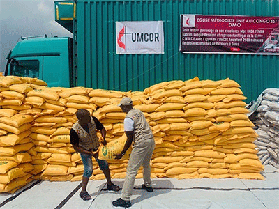 Jean Tshomba and Cudins Lokale, members of The United Methodist Church’s disaster management office in East Congo, lift bags containing rice and cornmeal during relief distribution in Goma in January 2023. Funding from the United Methodist Committee on Relief purchased more than 165 tons of food and non-food items distributed to more than 2,500 households or approximately 12,500 people. Photo by Chadrack Tambwe Londe, UM News.