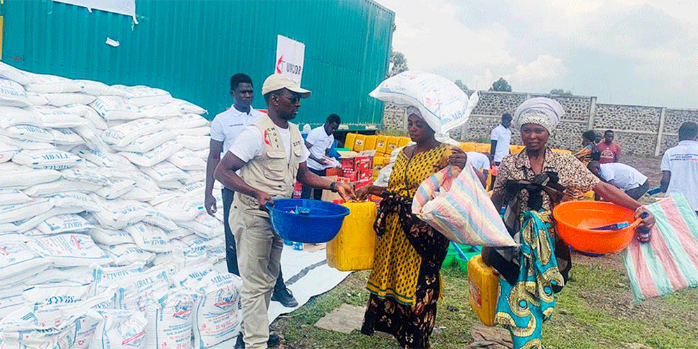 Jean Tshomba, coordinator of UMCOR's disaster management office in East Congo, delivers food and other relief items to a woman displaced by war. According to data provided by the United Nations Office for the Coordination of Humanitarian Affairs, more than 521,000 people, mainly women and children, are living with host families or in sites for displaced persons in the region. Photo by Chadrack Tambwe Londe, UM News.