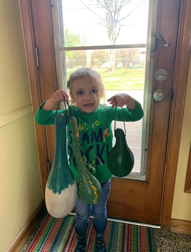 Julia shows off some gourds from the garden. Photo courtesy of Kay Eskridge.