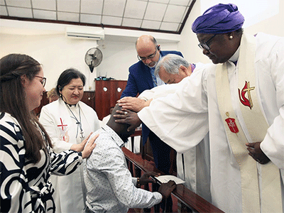 Global Mission Fellow Steven Chingadza (center) receives blessings during an April 20 commissioning service at Malanga United Methodist Church in Maputo, Mozambique. Laying hands on Chingadza are (clockwise from left) Hannah Hanson, director of young adult mission service at Global Ministries; the Rev. Judy Chung, executive director of missionary service at Global Ministries; Global Ministries top executive Roland Fernandes; Bishop Hee-Soo Jung and Bishop Joaquina Nhanala. Photo by Roque Facela.